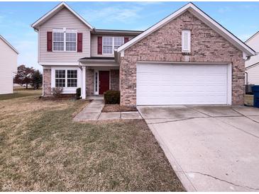 Charming two-story home featuring brick accents, a two-car garage, and a well-manicured front lawn at 6454 Waterstone Dr, Indianapolis, IN 46268