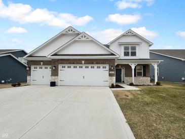 Charming home featuring a three-car garage, stylish brick accents, and inviting curb appeal at 6457 Flag Stop Dr, Whitestown, IN 46075