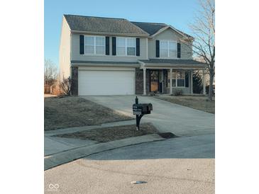 Charming two-story home featuring a two-car garage and a welcoming front porch at 7018 Allegan Dr, Indianapolis, IN 46217