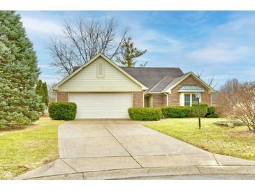 Charming brick home with a two-car garage and a well-manicured front lawn on a sunny day at 8221 Furlong Cir, Indianapolis, IN 46256