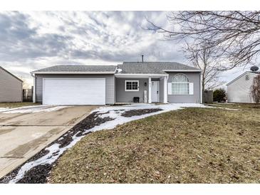 Charming home with a two-car garage, and well-manicured lawn on a cloudy day at 163 Country Wood Dr, Whiteland, IN 46184