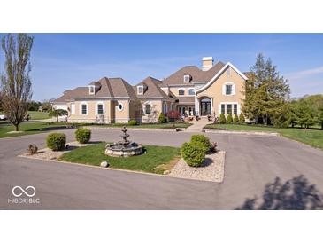 Elegant home with a circular driveway, mature landscaping, and a charming water fountain at 2766 S Honey Creek S Rd, Greenwood, IN 46143