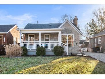 Charming home featuring a stone facade, covered porch, well-maintained landscaping, and a cozy curb appeal at 6225 Indianola Ave, Indianapolis, IN 46220