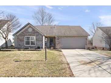 Charming single-story brick home with a well-maintained lawn and an attached two-car garage and concrete driveway at 10373 Cerulean Dr, Noblesville, IN 46060