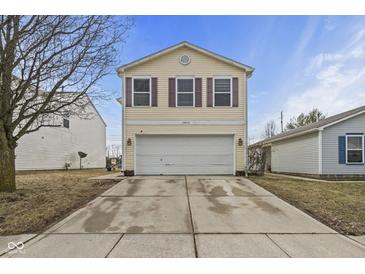 Charming two-story home with a two car garage, yellow siding, and purple window shutters at 10613 Glenayr Dr, Camby, IN 46113