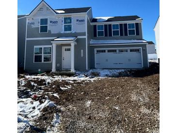 Charming two-story home featuring a welcoming entrance, garage, and symmetrical window design at 13820 N Fairwood Dr, Camby, IN 46113