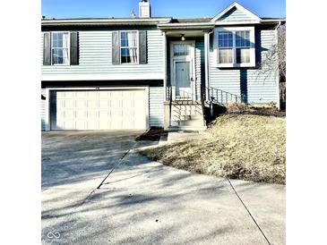 Charming two-story home featuring light blue siding, attached garage, and well-manicured lawn at 3766 N Lakeside Dr, Muncie, IN 47304