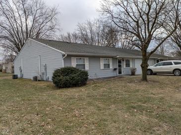 Charming single story home with light grey siding and inviting front yard at 8002 Bryan Dr, Indianapolis, IN 46227
