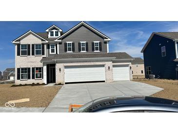 Beautiful two-story home featuring a three-car garage, gray siding, white brick, and black window shutters at 10218 Cliff Ln, Indianapolis, IN 46239
