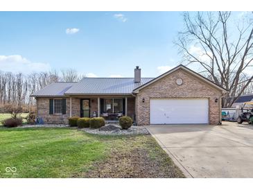 Charming brick home with a metal roof, two car garage, and well-manicured lawn at 1194 S 300 E, Anderson, IN 46017