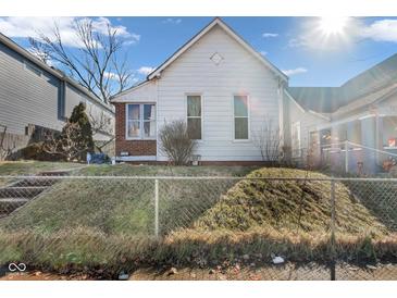 Charming home with a gabled roof, set on a raised yard with a chain-link fence at 125 Kansas St, Indianapolis, IN 46225