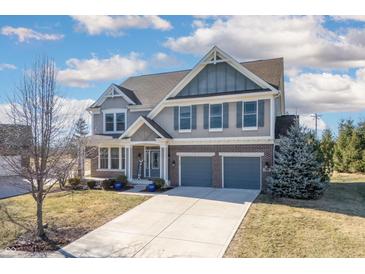 Two-story home featuring a two-car garage, brick accents, and a well-manicured lawn at 12650 Misty Ridge Ct, Fishers, IN 46037