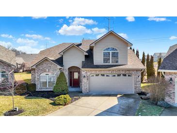 Charming two-story home featuring a brick and siding exterior with an attached two-car garage and well-manicured landscaping at 4139 Bella Ct, Indianapolis, IN 46237