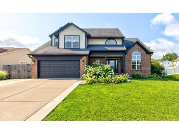 Charming two-story home with a well-manicured lawn and beautiful landscaping at 4889 Oakleigh Pkwy, Greenwood, IN 46143
