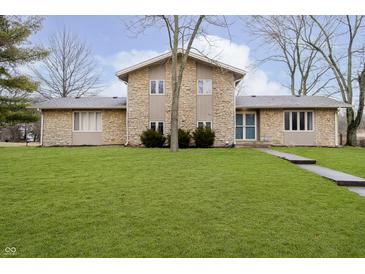 Charming stone two-story home with a well-manicured lawn at 647 Mulford Ct, Indianapolis, IN 46234