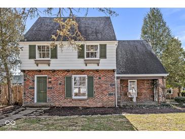 Charming brick home with green shutters, a quaint entrance, and lush landscaping at 83 W Garfield Ave, Martinsville, IN 46151