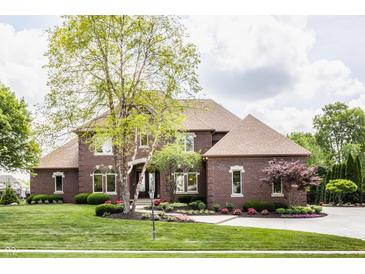 Charming two-story brick home with a meticulously landscaped front yard and well manicured lawn at 10541 Titan Run, Carmel, IN 46032