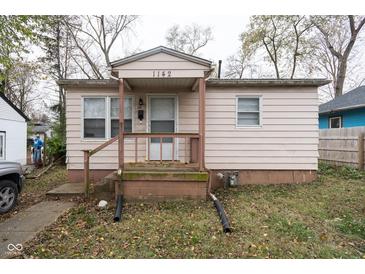Charming single-story home featuring a covered porch, light siding, and a well-maintained front yard at 1142 Sharon Ave, Indianapolis, IN 46222