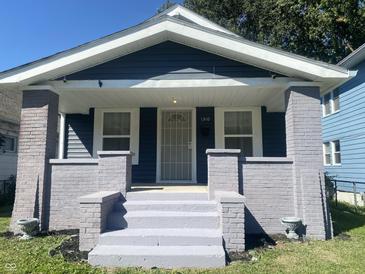 Charming home featuring a covered front porch with decorative columns and freshly painted stairs at 1310 N Lasalle St, Indianapolis, IN 46201