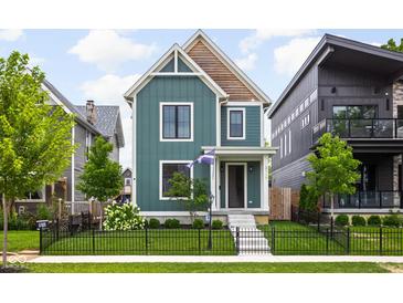 Charming two-story home boasts lush lawn, landscaping, and a welcoming front entrance with a well-manicured lawn at 2117 Broadway St, Indianapolis, IN 46202
