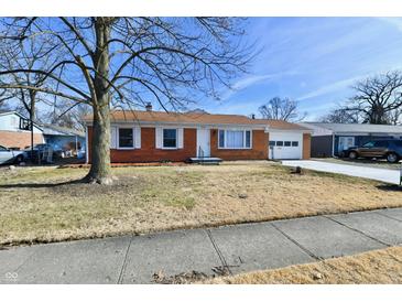 Charming brick ranch home featuring white trim, an attached garage and a well manicured front yard at 2521 Beechcrest Dr, Indianapolis, IN 46203