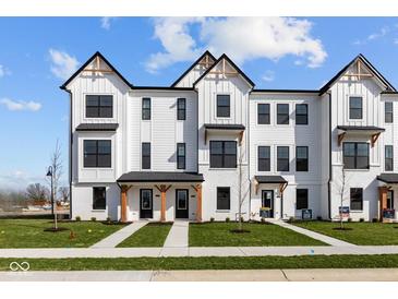 Newly built white farmhouse townhomes with black trim and inviting front yards at 4150 Douro Trl, Westfield, IN 46062