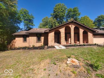 Charming brick home featuring arched entryway and freshly landscaped front yard at 8940 Black Hawk Ln, Indianapolis, IN 46234