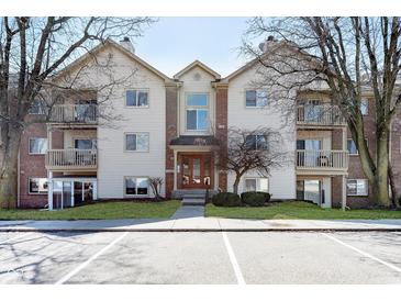 Exterior view of a three story condo with manicured lawn and ample parking in front at 1057 Timber Creek Dr # 12, Carmel, IN 46032