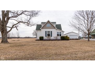 Charming two-story home with green roof and a detached garage, surrounded by an open yard at 3615 E State Rd 32, Lebanon, IN 46052