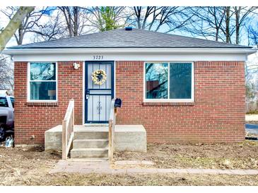 Charming brick home featuring a welcoming front door with a wreath and a small front porch at 3723 N Olney St, Indianapolis, IN 46218