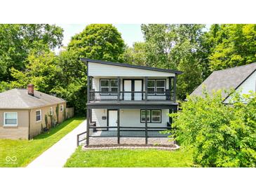 Charming two-story home featuring a spacious double-decker porch with stylish black railings and a well-maintained lawn at 4242 Winthrop Ave, Indianapolis, IN 46205
