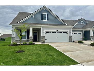 Charming home featuring a two-car garage, and a well-manicured front lawn at 50 Hovden Dr, Cicero, IN 46034