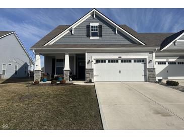 Charming home featuring a two car garage, stone accents, and a well-manicured lawn at 50 Hovden Dr, Cicero, IN 46034