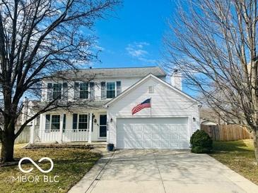 Charming two-story white home features a two car garage and an American flag at 5632 Willowridge Ct, Indianapolis, IN 46221