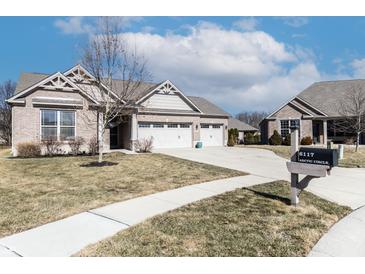 Beautiful brick home featuring a two car garage, a manicured lawn and mature landscaping at 6117 Arctic Cir, Indianapolis, IN 46237