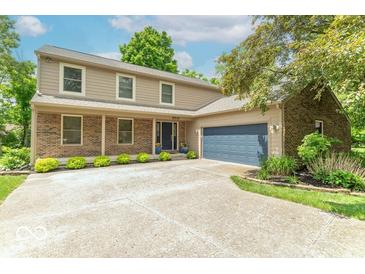 Charming two-story home featuring a brick facade, manicured lawn, and an attached two-car garage at 6530 Grant Wood Ct, Indianapolis, IN 46256