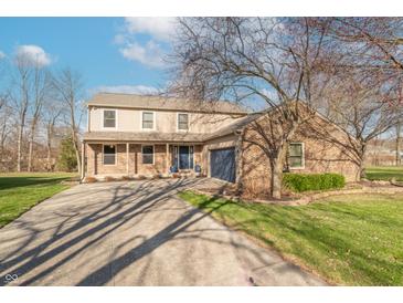 Charming two-story home with a brick facade, blue door, and attached two-car garage at 6530 Grant Wood Ct, Indianapolis, IN 46256