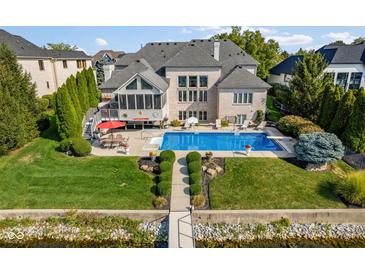 Aerial view of backyard with pool, dock, and manicured landscaping at 13499 Marjac Way, Fishers, IN 46055