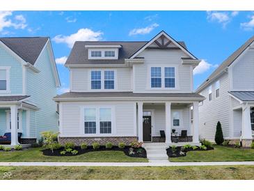 Charming two-story home featuring a landscaped yard, covered entry, and a classic architectural design at 1935 Ponsonby Dr, Westfield, IN 46074