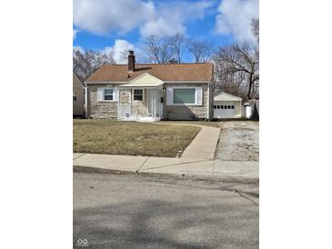 Charming single-story home features stone accents, a covered porch, and a detached garage at 2006 Medford Ave, Indianapolis, IN 46222