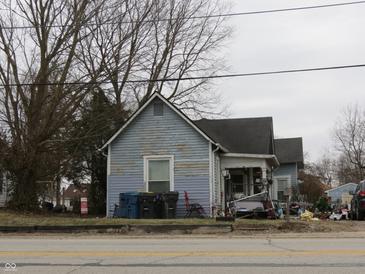 Exterior view of a two-story home with weathered siding and an overgrown front yard at 250 S Marion St, Morgantown, IN 46160