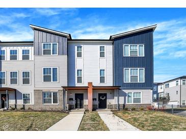 New townhouse exteriors feature blue and gray siding, front porches, concrete walkways and professionally landscaped yards at 3046 W New York St, Indianapolis, IN 46222