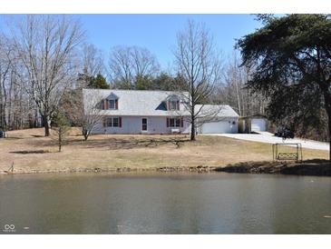 Charming exterior view of home, featuring a picturesque pond and lush greenery at 3546 Stierwalt Rd, Quincy, IN 47456