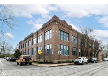 Brick apartment building featuring large windows, street parking, and manicured landscaping around the perimeter at 735 Lexington Ave # 30, Indianapolis, IN 46203