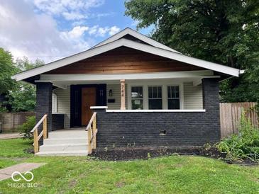 Charming single-story home featuring dark brick accents, a cozy front porch, and a well-manicured lawn at 744 Wallace Ave, Indianapolis, IN 46201