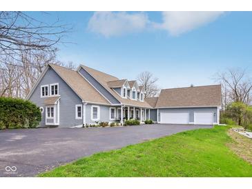 Spacious home with three-car garage, light-blue siding, and well-manicured lawn and mature trees at 8015 Sargent Rdg, Indianapolis, IN 46256