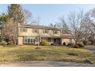 Two-story home featuring stone accents and a solar-paneled roof on a well-maintained lawn at 9080 Dewberry Ct, Indianapolis, IN 46260