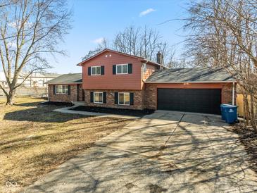 Two-story home featuring a two-car garage, brick accents, and a long driveway at 1431 W Edgewood Ave, Indianapolis, IN 46217