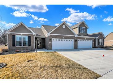 Beautiful home showcasing a well-manicured lawn, driveway, attached garages, and appealing architectural features at 1684 Hedley W Way, Avon, IN 46123