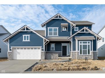 Charming two-story home featuring a blue facade, white trim, stone accents, and an attached two-car garage at 19854 Chatham Shore Ln, Westfield, IN 46074